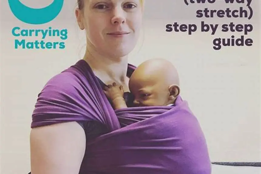 Parent placing newborn in a stretchy baby wrap indoors