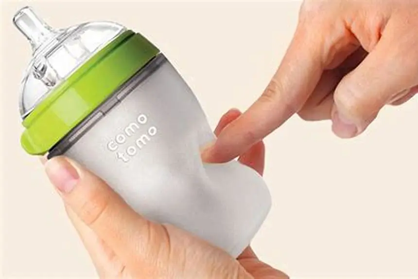 Comotomo baby bottle being cleaned in kitchen sink