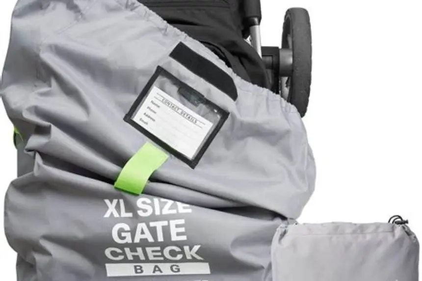 Folded stroller zipped into a padded black travel bag at an airport gate